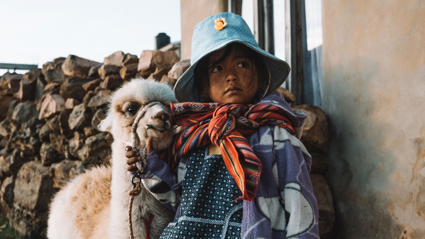 Girl with baby llama on Isla del Sol in Bolivia