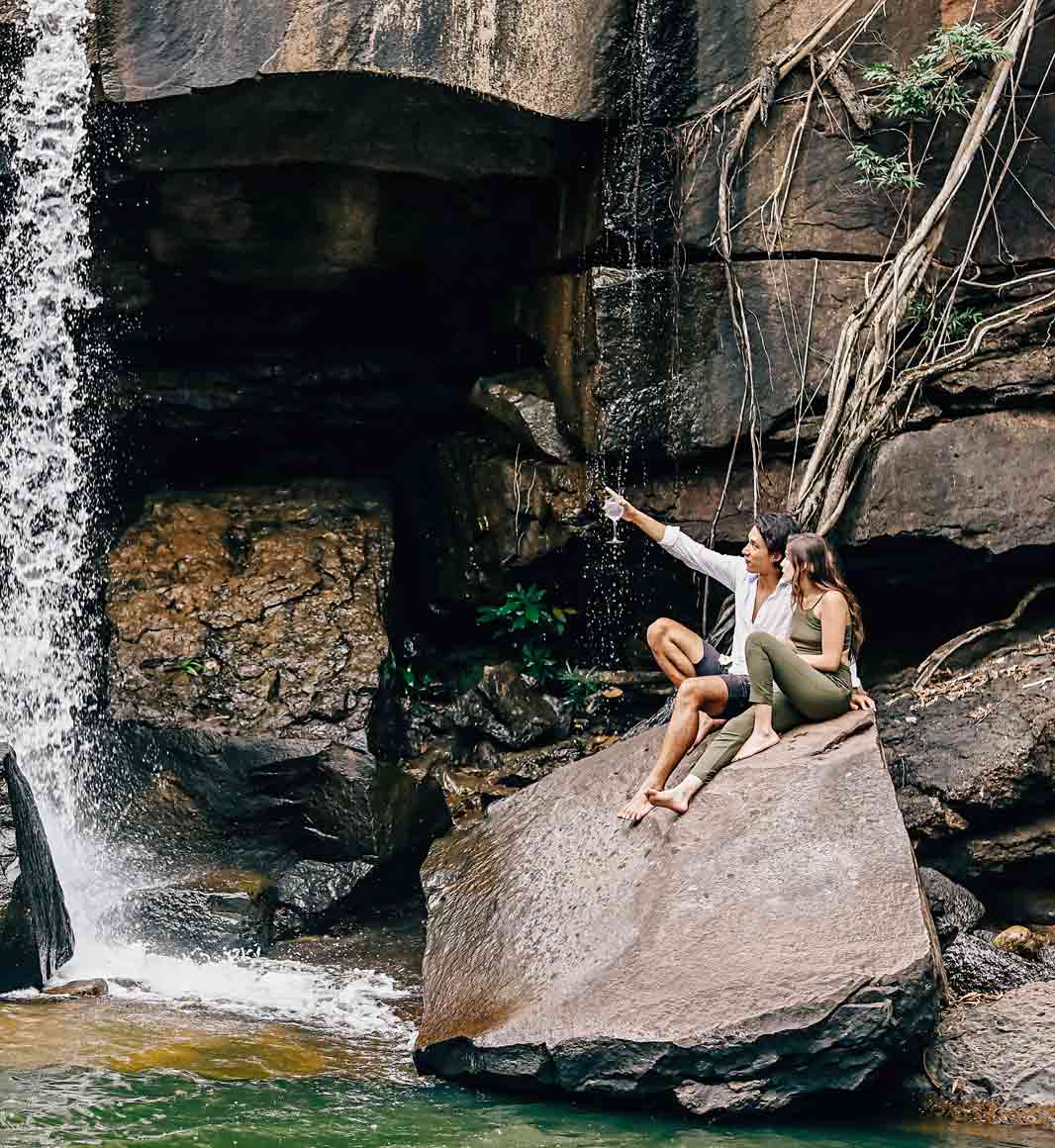 Couple by waterfall in Cardamom Mountains, Cambodia
