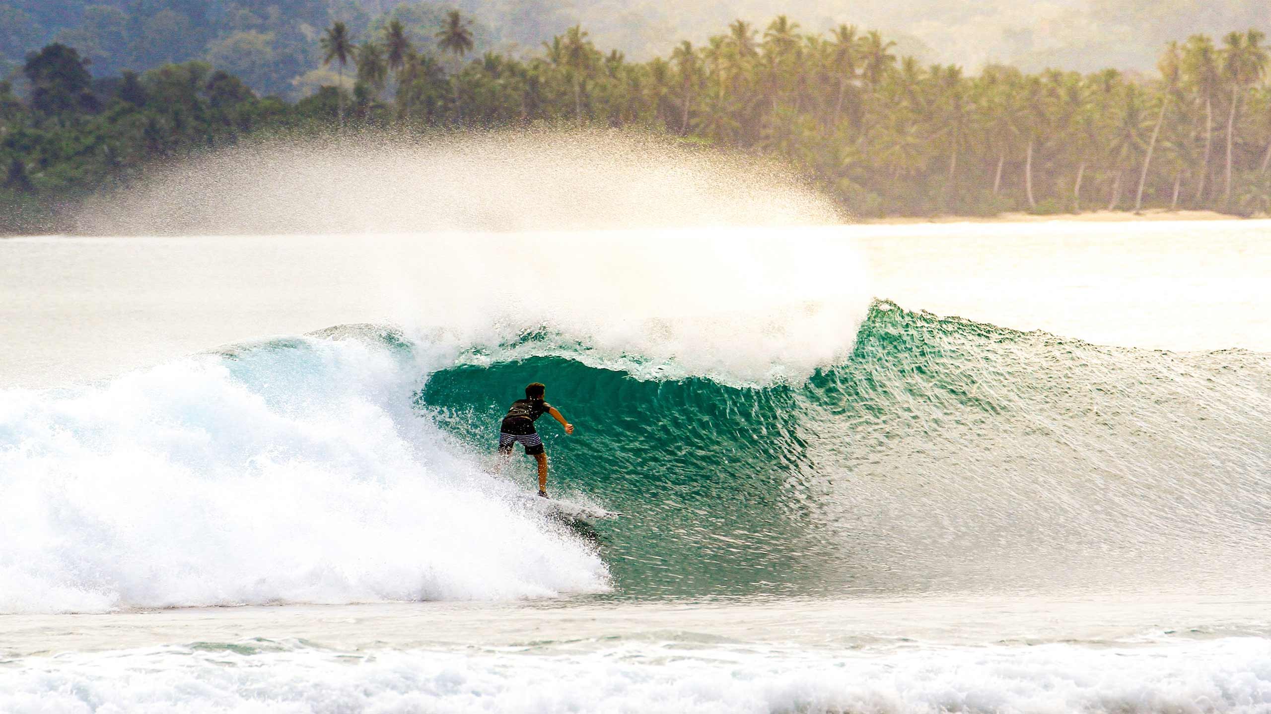 Surfing waves in the Mentawai Islands in Indonesa