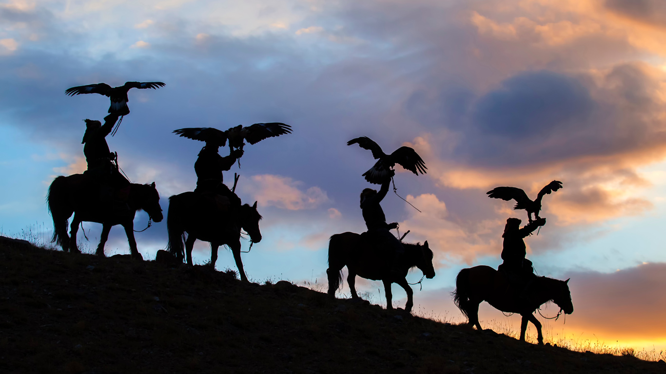 Eagle hunters at sunset in Mongolia