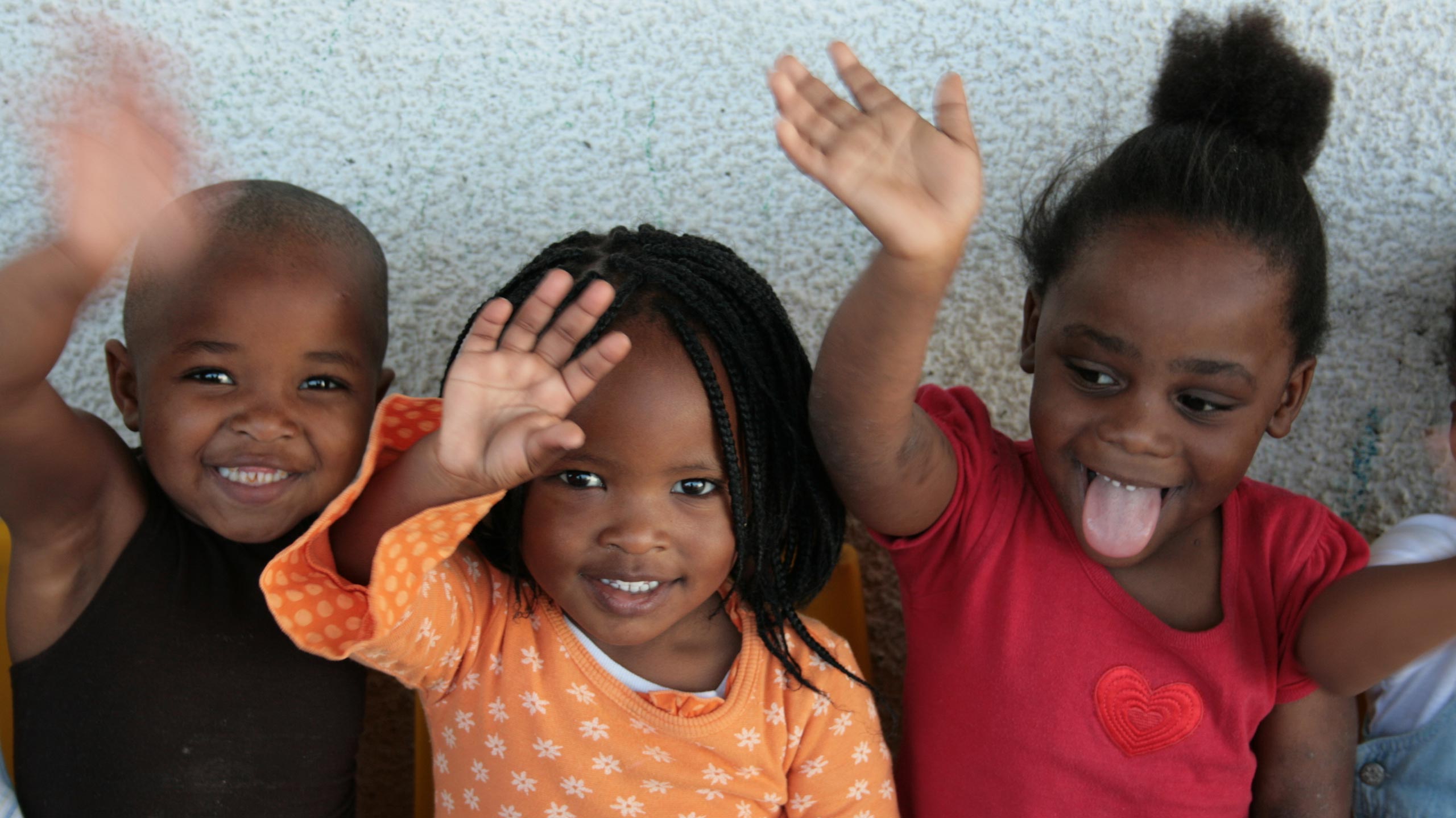 Children waving at camera in Cape Town, South Africa
