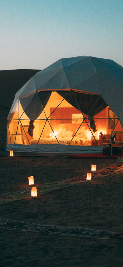View of desert luxury camp set up in Sahara Desert in Morocco at night