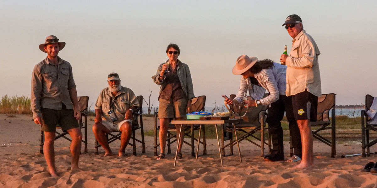 sundowners on the beach at musango safari camp in zimbabwe