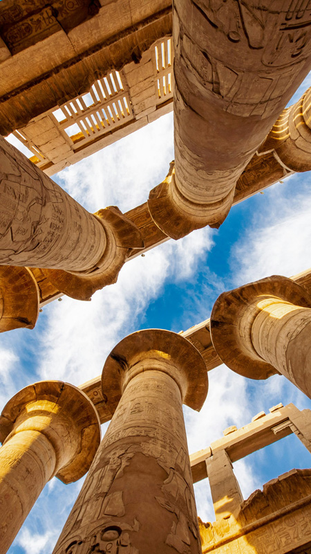 view through the pillars of a luxor temple towards the sky