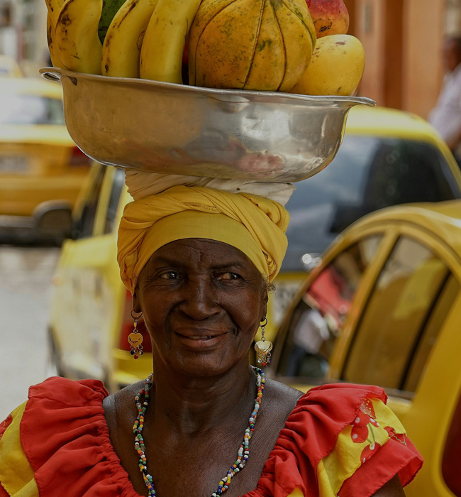 woman carrying bananas on her head in cartegena colombia