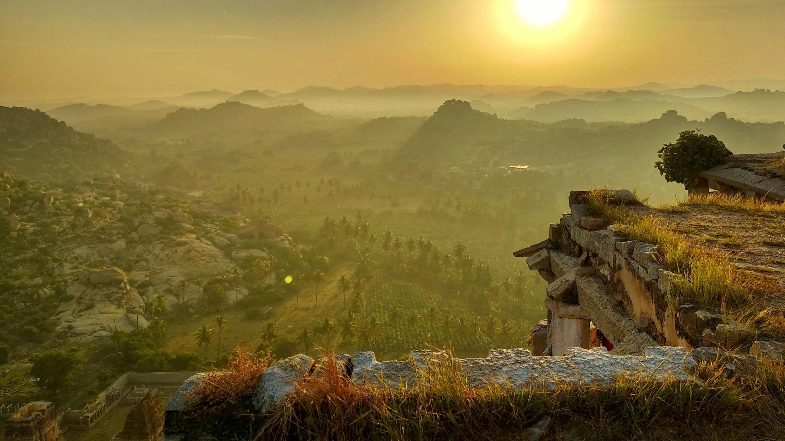 view of hampi archeological site in india at sunset from the top of a temple