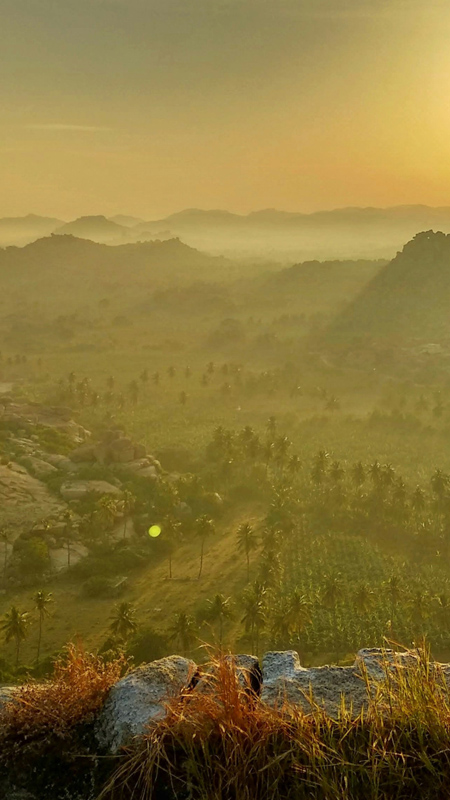 view of hampi archeological site in india at sunset from the top of a temple