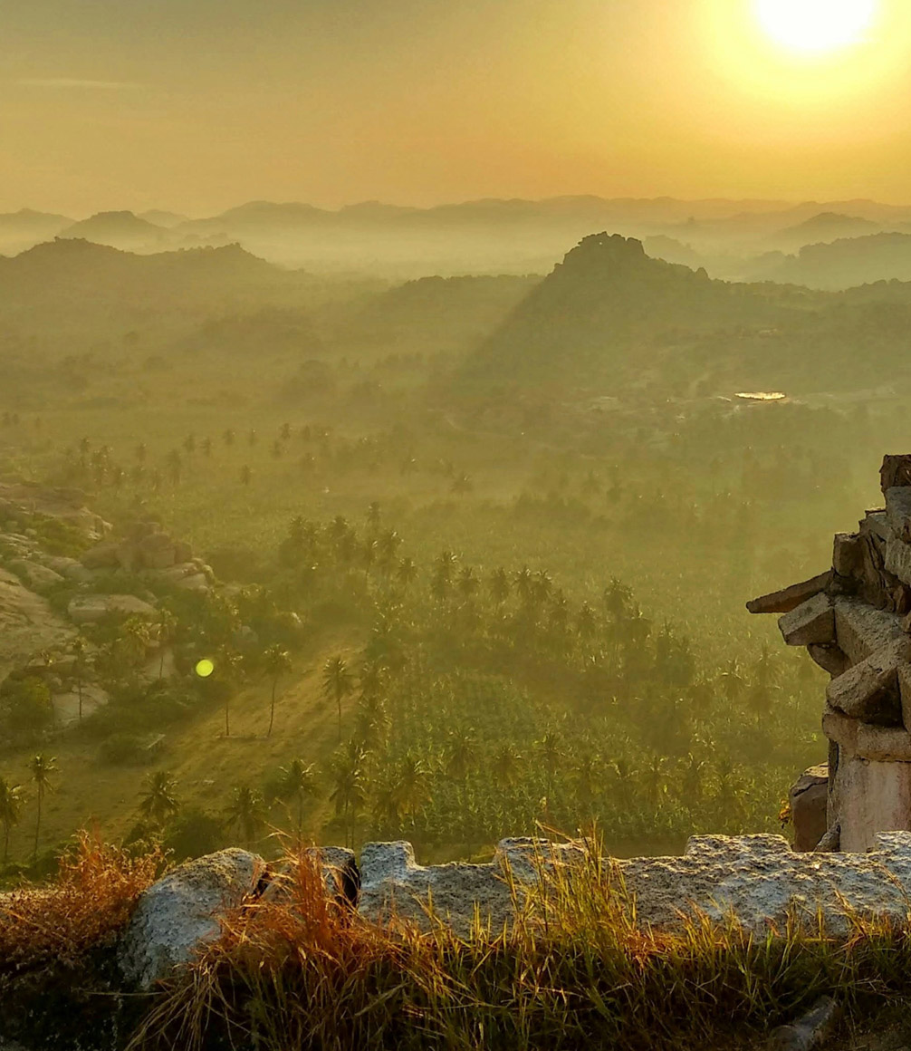 view of hampi archeological site in india at sunset from the top of a temple