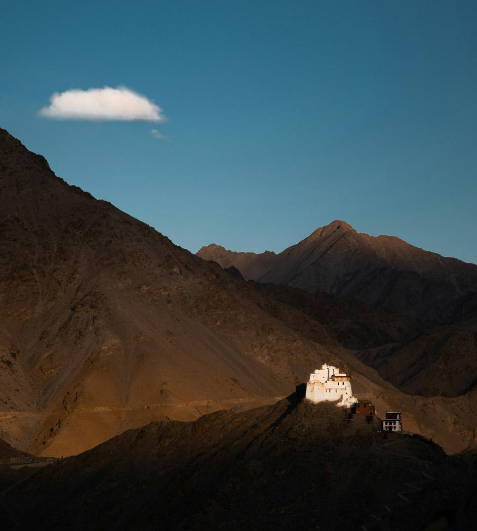 monastery on hilltop in ladakh set against the mountains