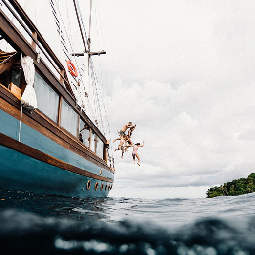 family jumping from dewata yacht