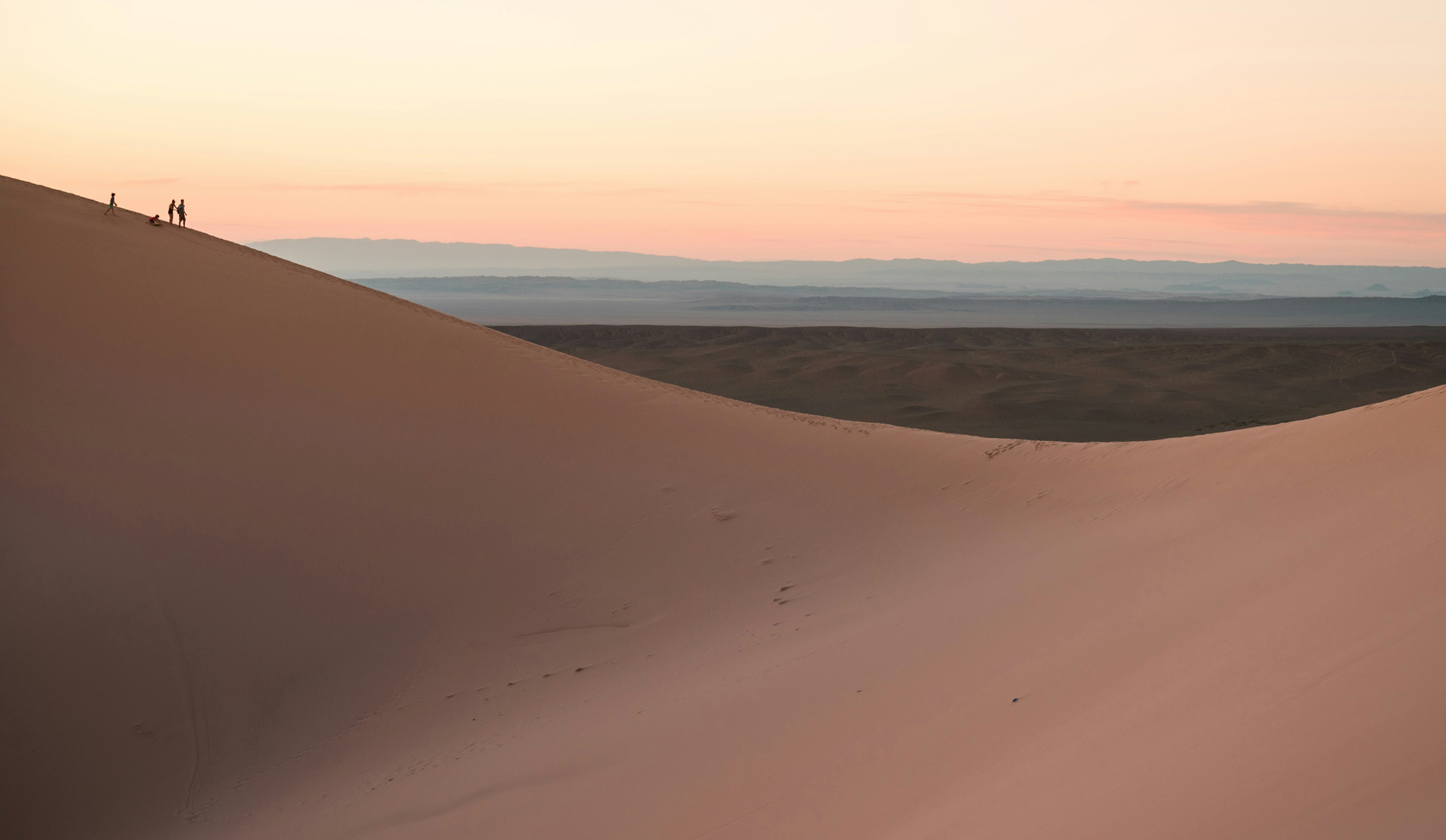 mongolia's desert with guests standing on a dune