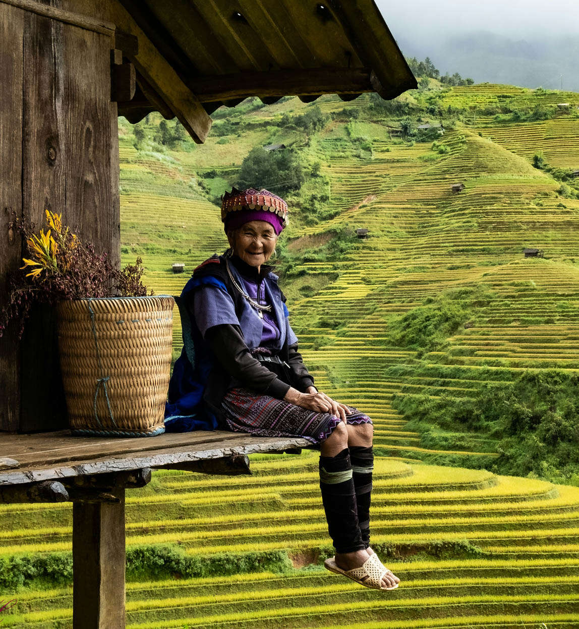 woman sat on deck of house in the rice paddies in vietnam