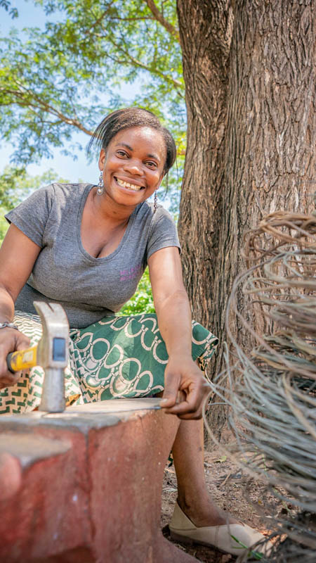 zambian woman creating jewellery from snare wire at mulberry mongoose