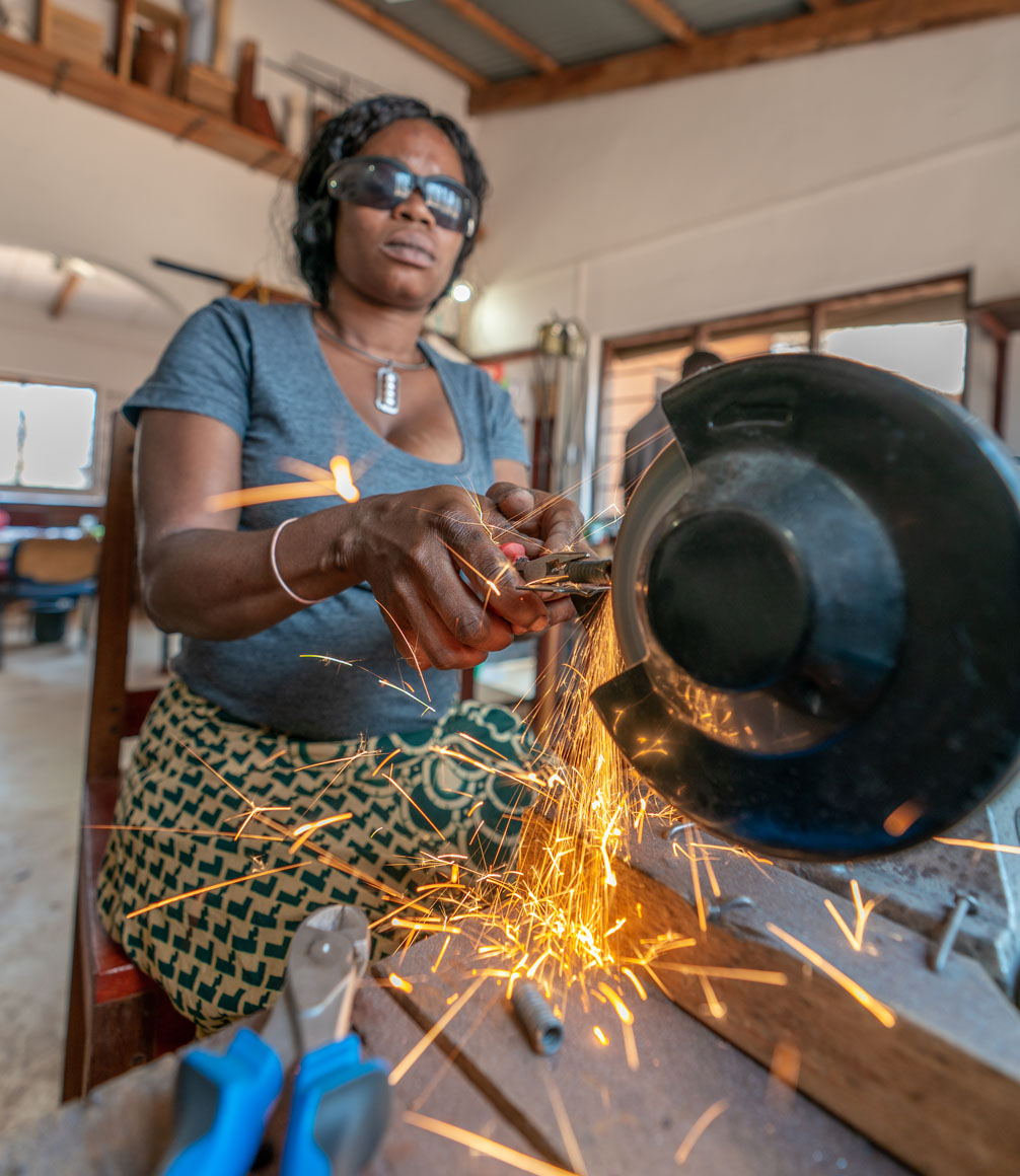 zambian woman at mulberry mongoose workshop grinding wire into jewellery