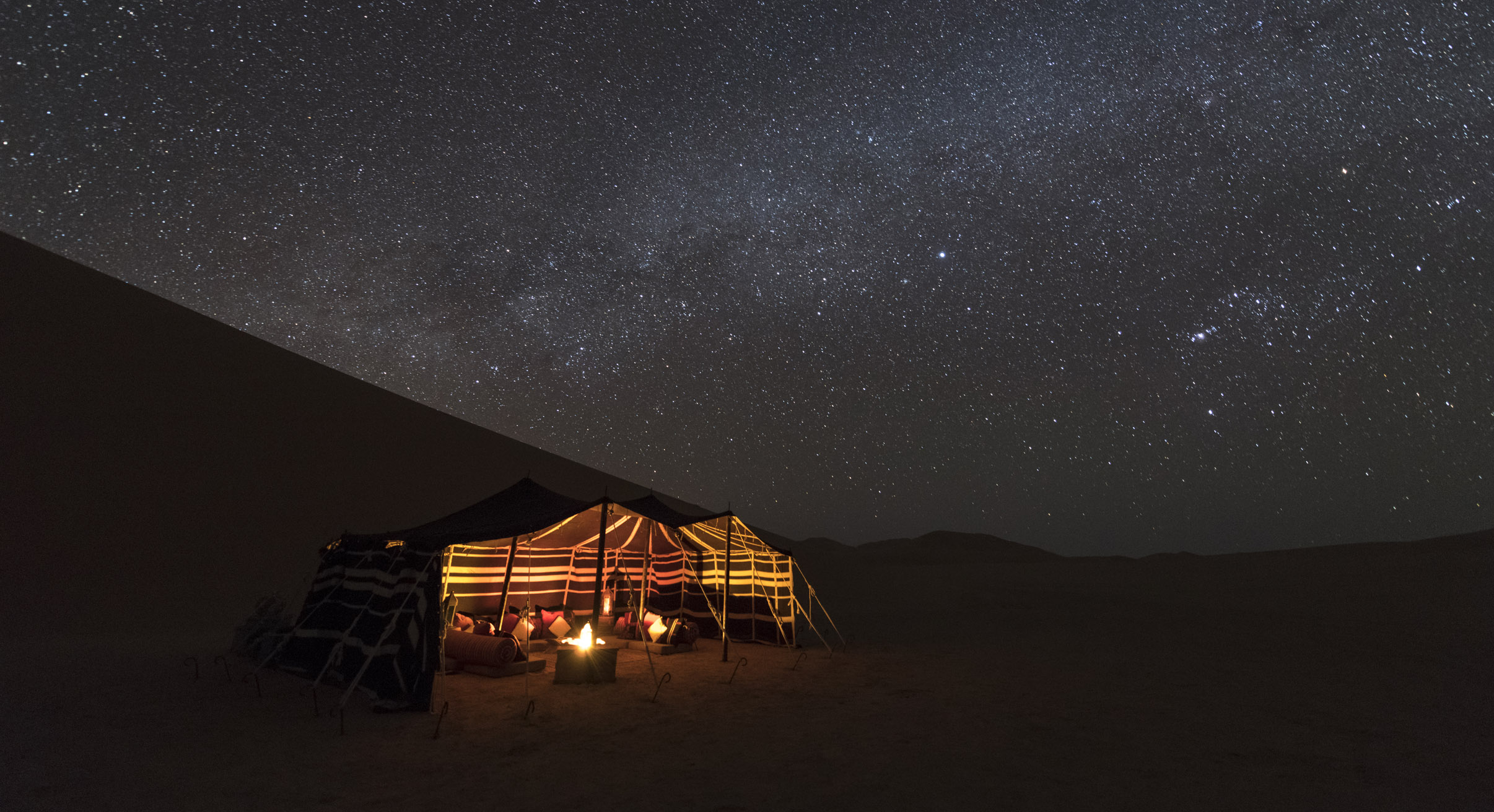 luxury desert camp at night in oman's empty quarter