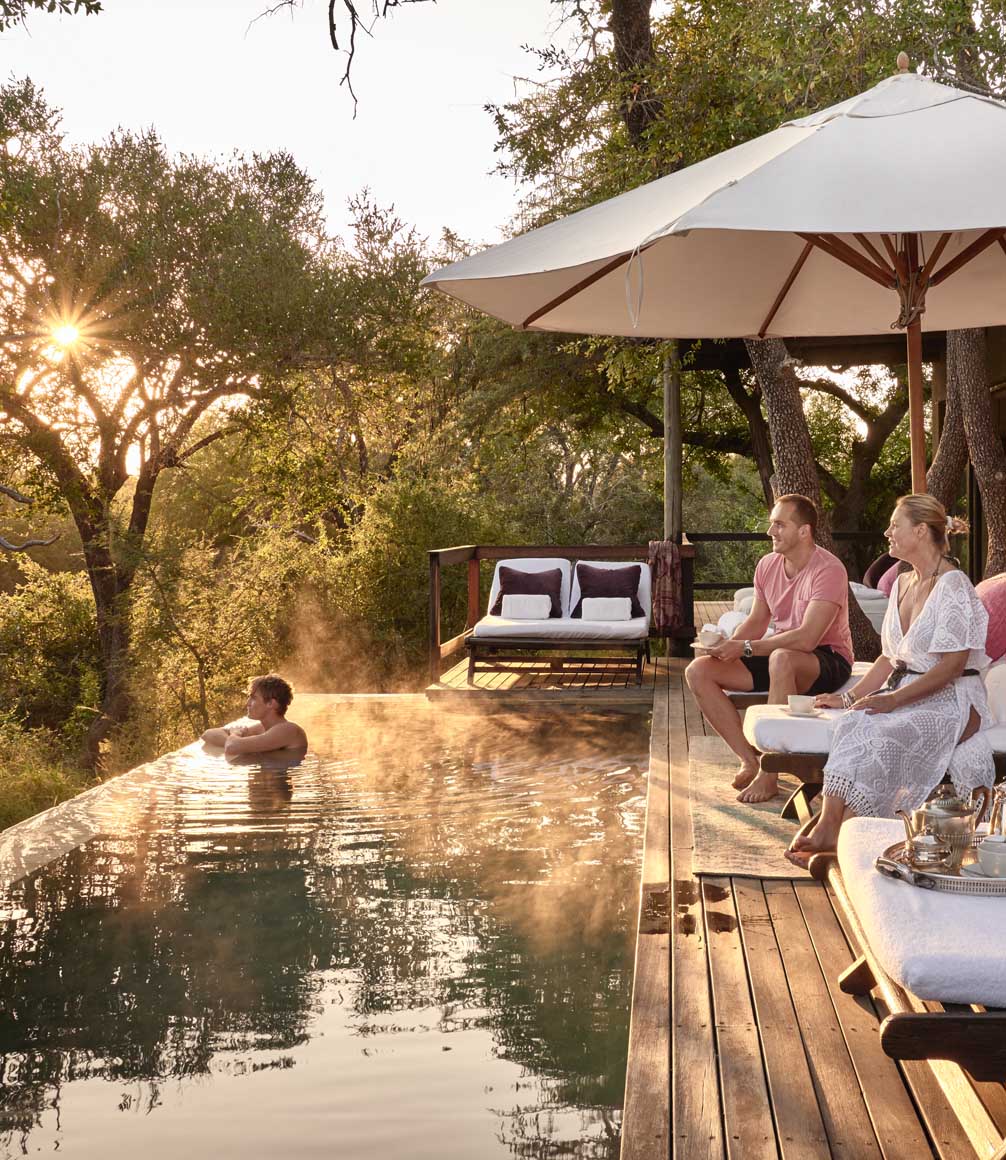 family sat around pool on a family safari at royal malewane in south africa