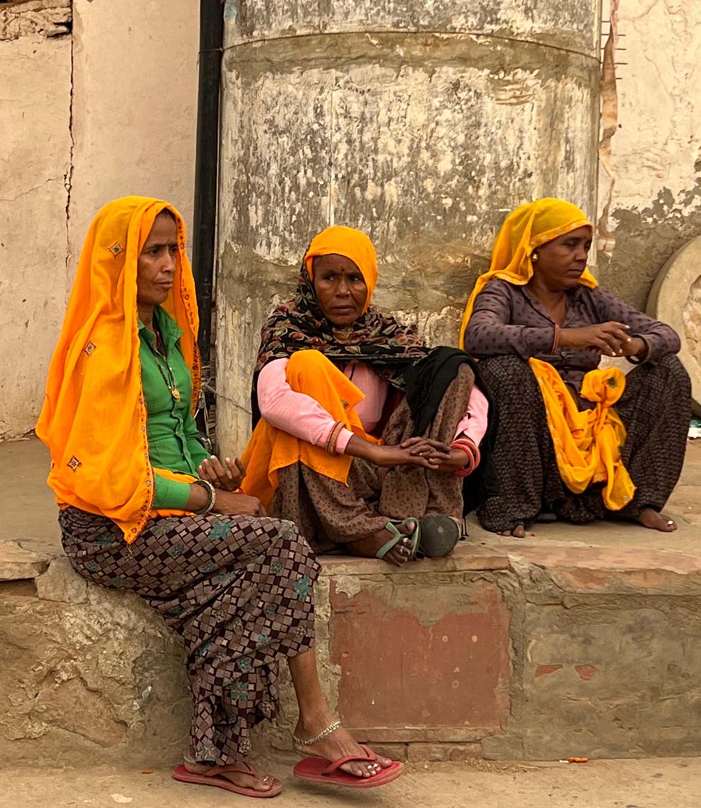 three women in jaipur wearing traditional colourful textiles