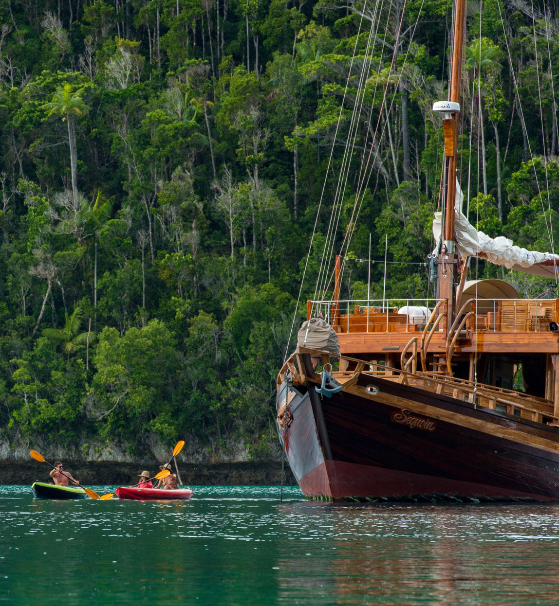 sequia yacht in raja ampat with kayaking guests nearby