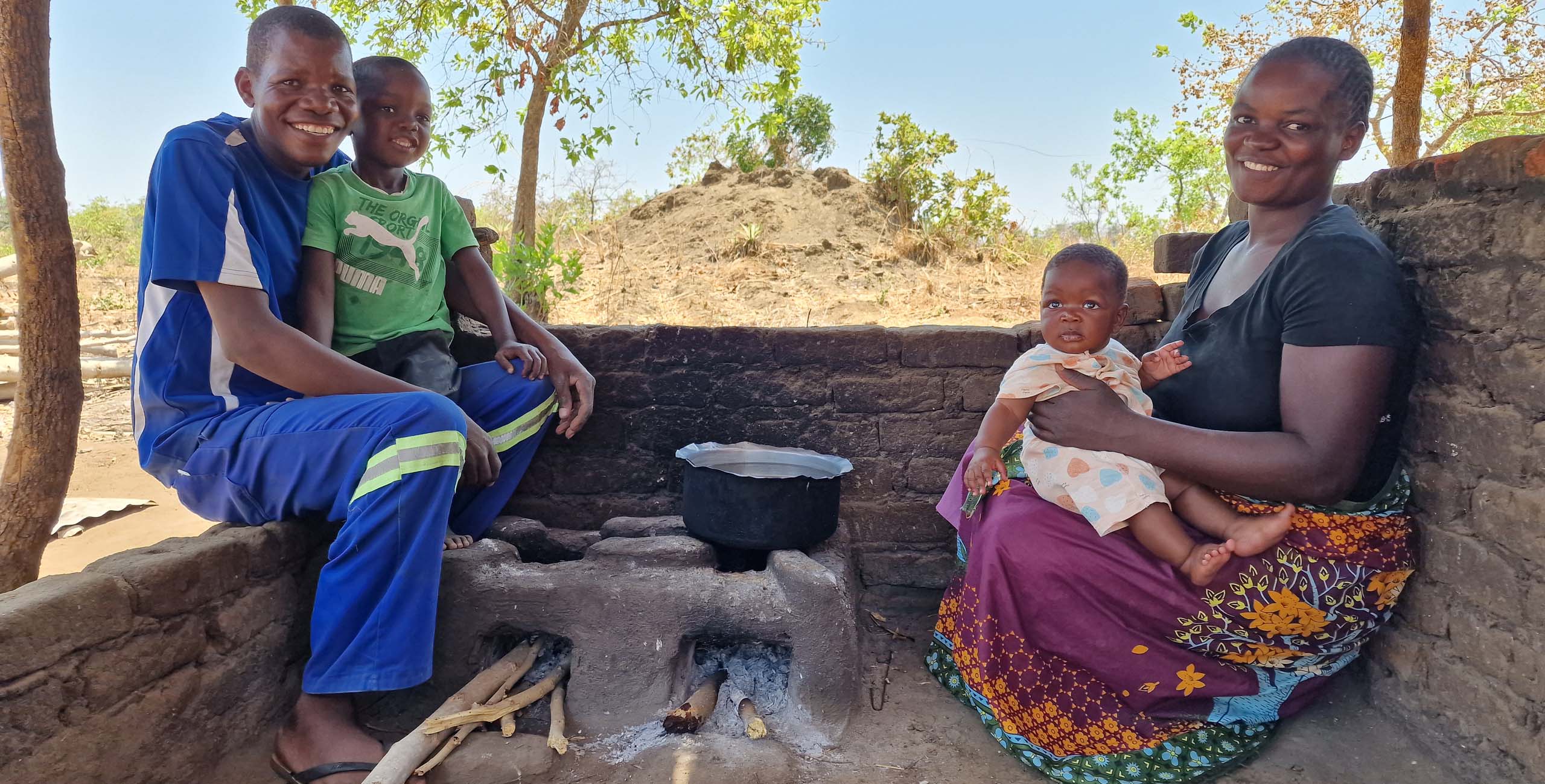 family with their fuel efficient cookstove in malawi