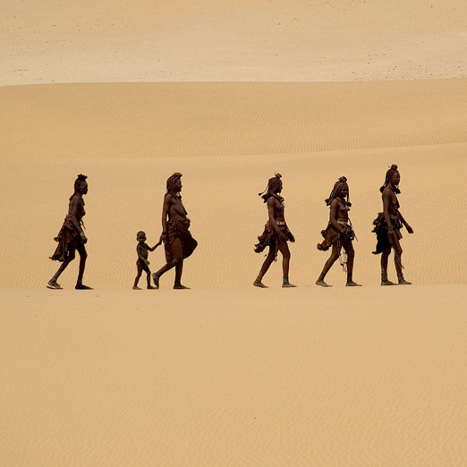 himba people walking through the namib desert