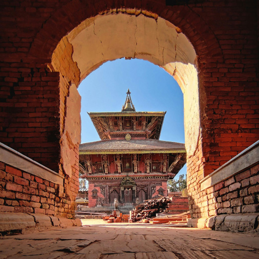 kathmandu durbar square and stupa viewed through arch