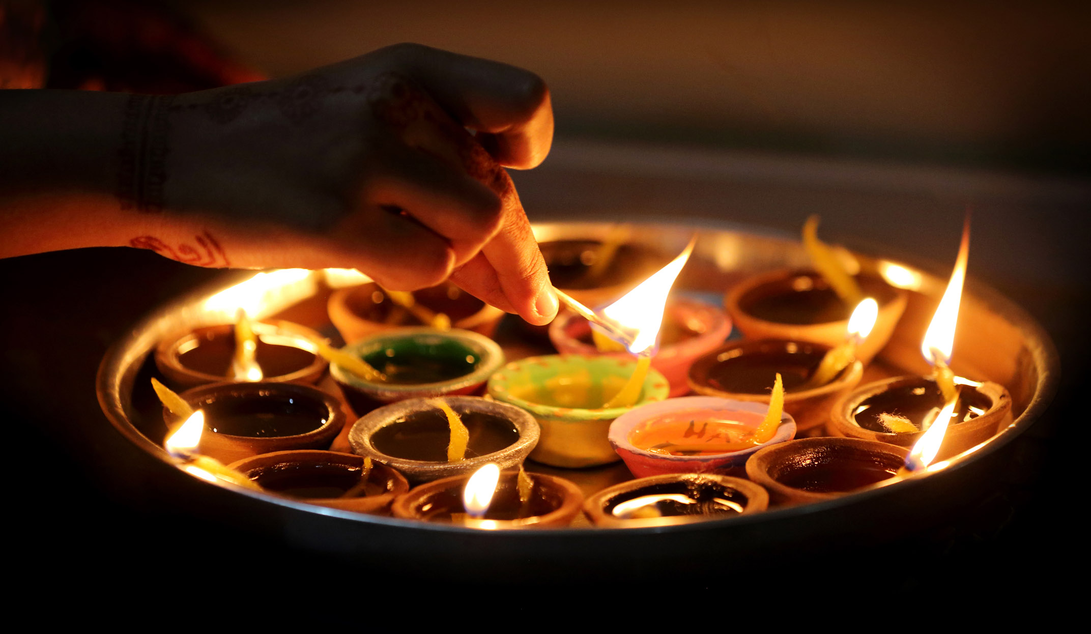 Traditional diya clay lamps being lit in aarti ceremony