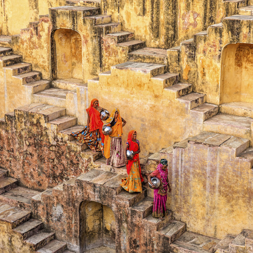 ladies in indian dress walking down the steps of a stepwell in jaipur
