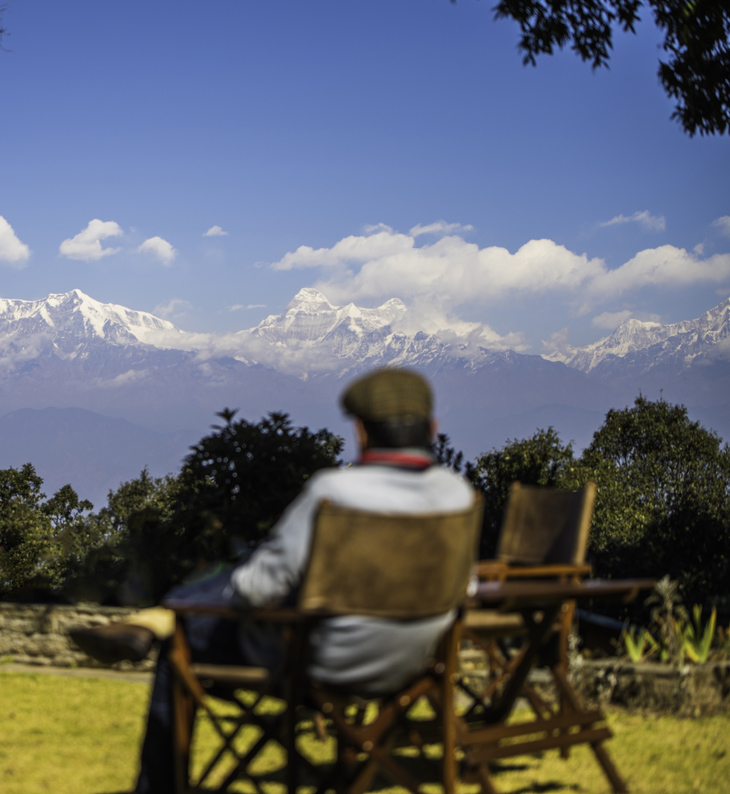 man sitting on verandah at nine furlongs looking at the mountain view