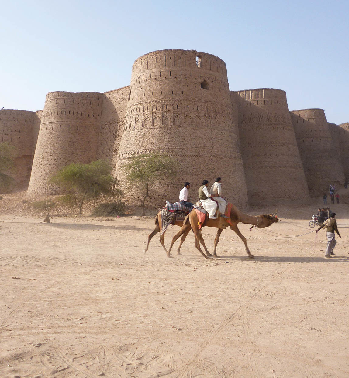 derawar fort exterior with camels walking in front