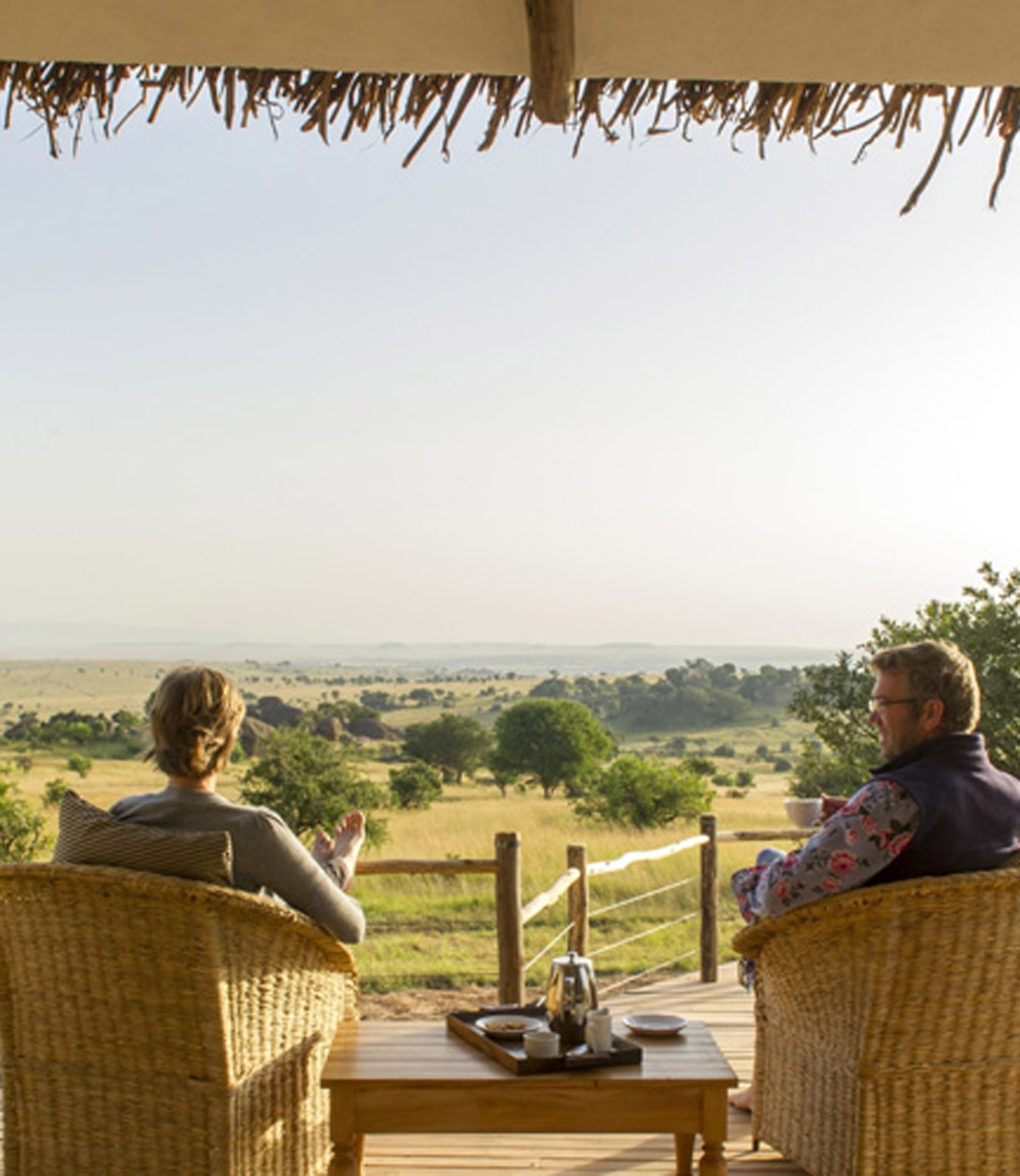 parents relaxing on verandah at mkombe's house in the serengeti on a tanzania family safari
