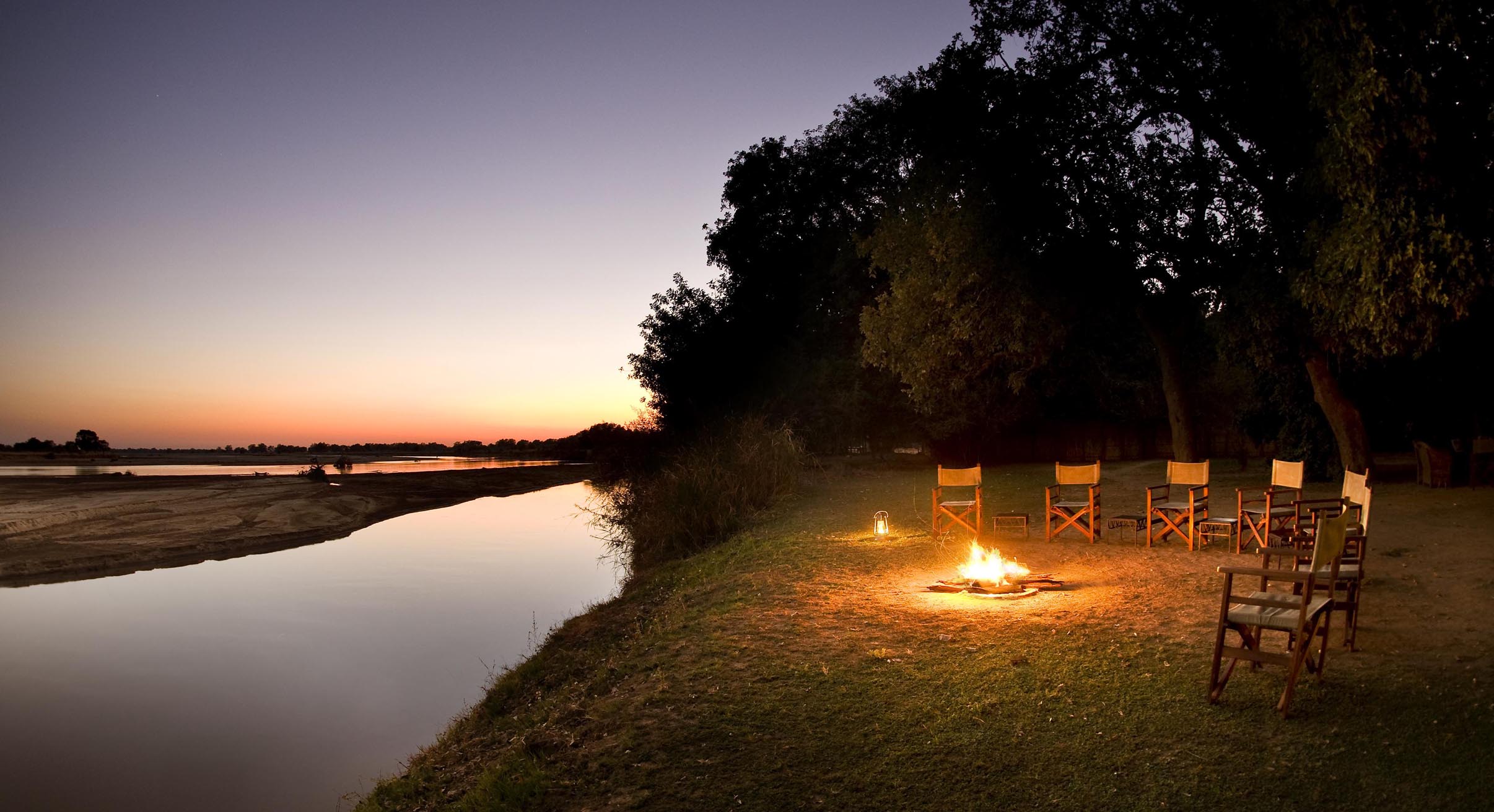 the campfire at tafika camp lit for sunrise by the river