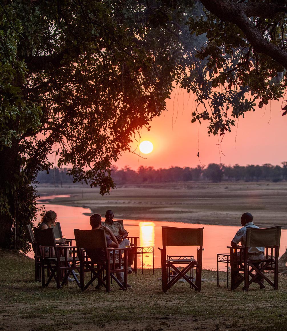 sundowners by the river at tafika camp