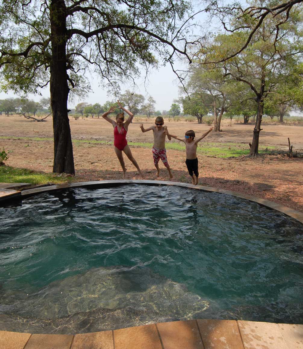 kids jumping into the pool at luangwa safari house