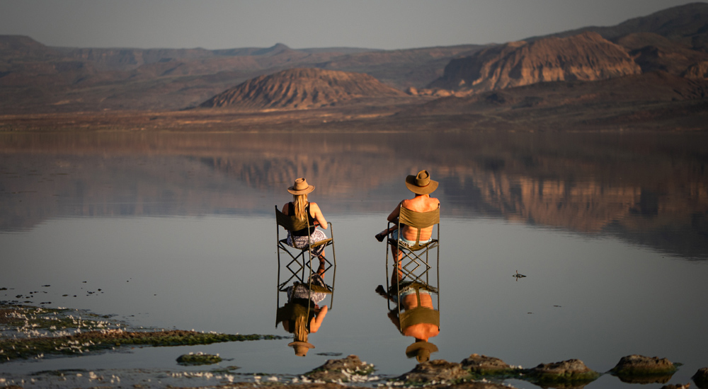 guests taking sundowners on the shores of lake logipi at ol malo, kenya
