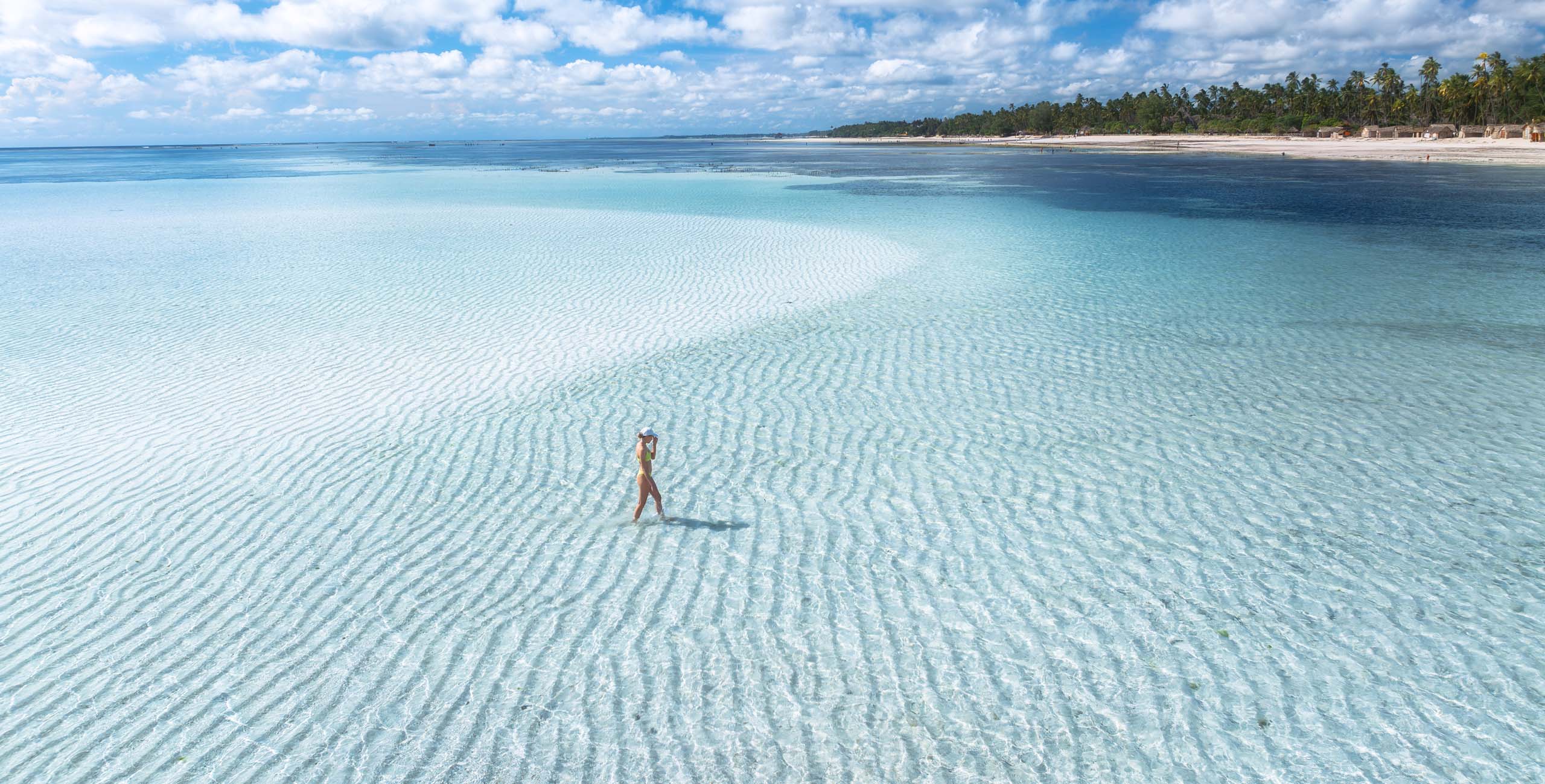 woman on sandbar off beach in zanzibar tanzania