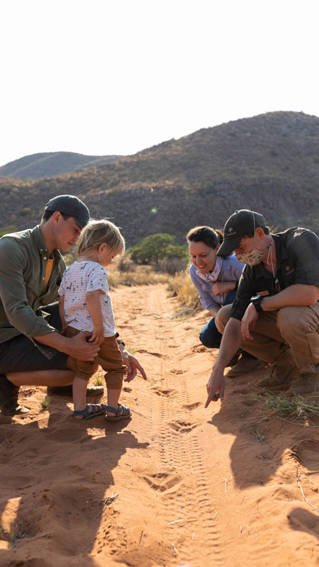 family on safari at tswalu in south africa learning how to track animals by spoor tracking - Image by Caitlin Smit