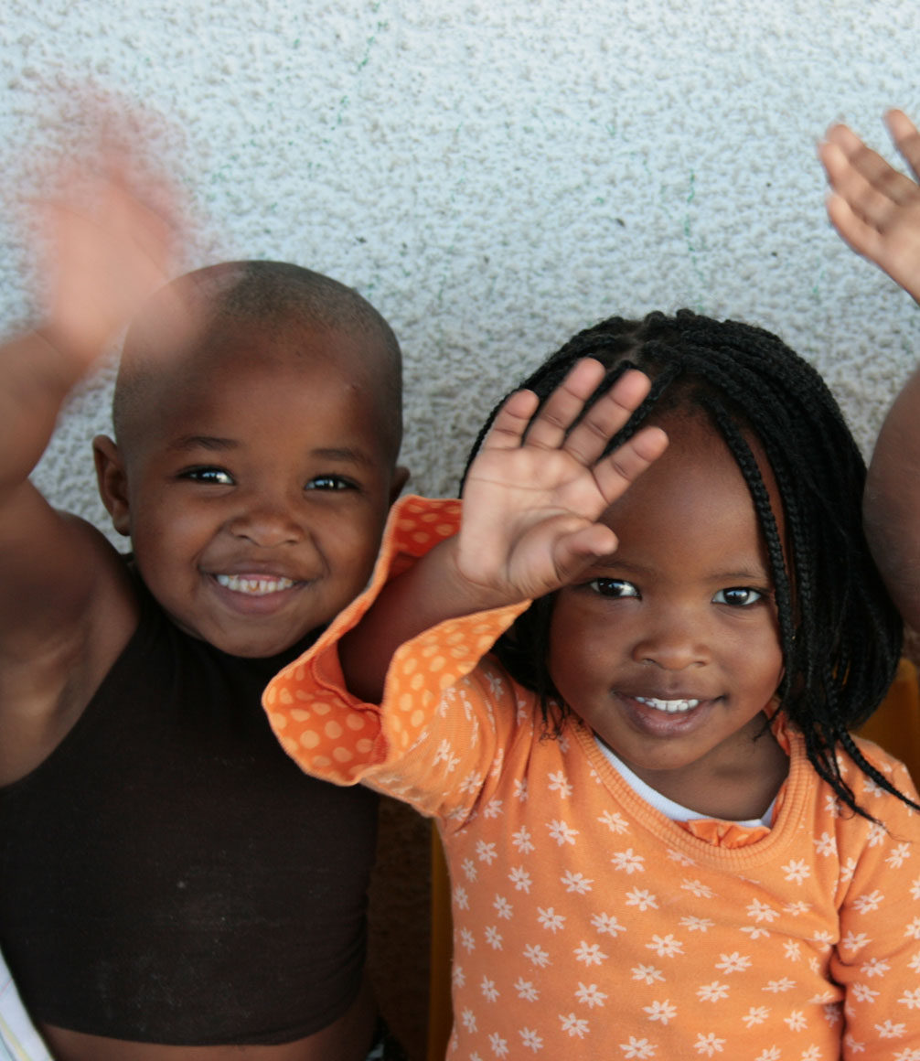 Child waving at camera at uthando's childrens education system in Cape Town, South Africa