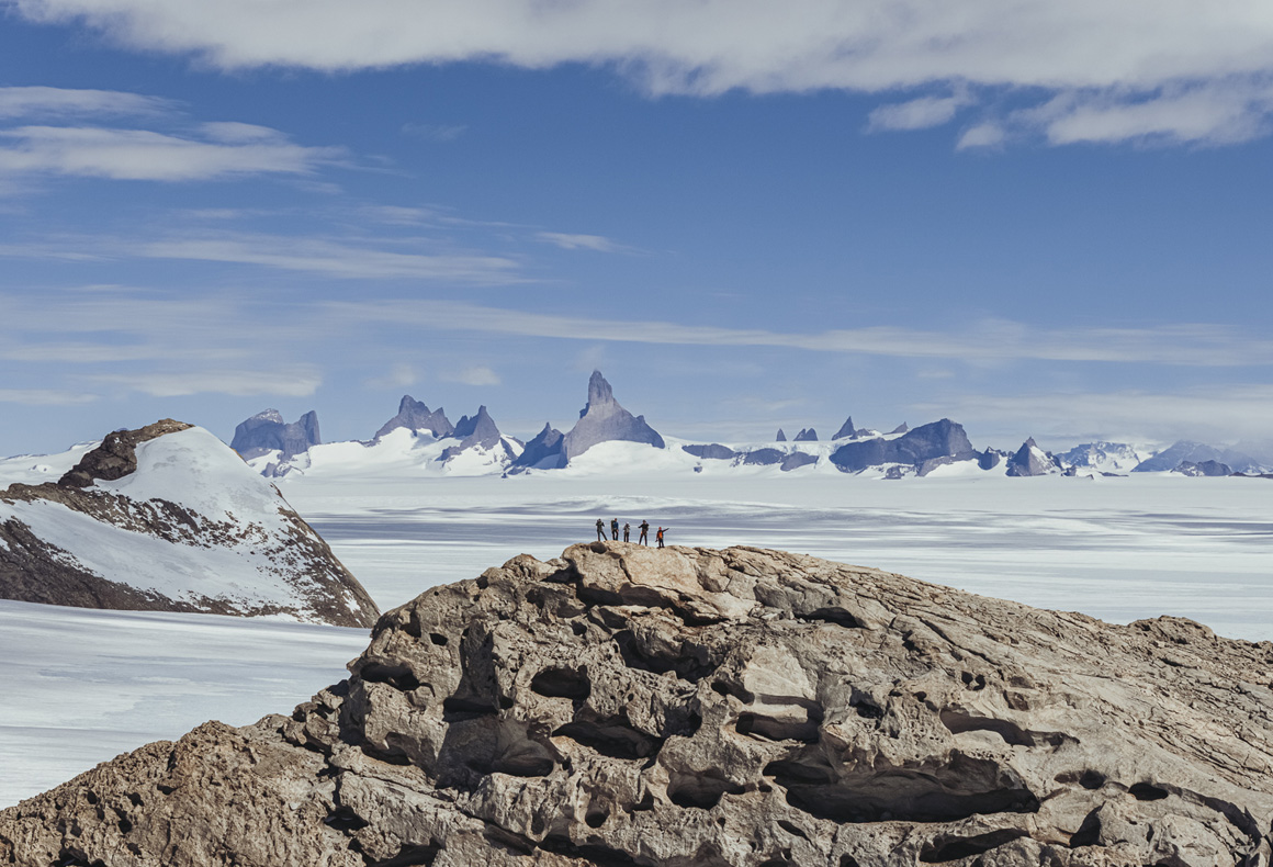 view of antarctica landscape with guests on mountaintop