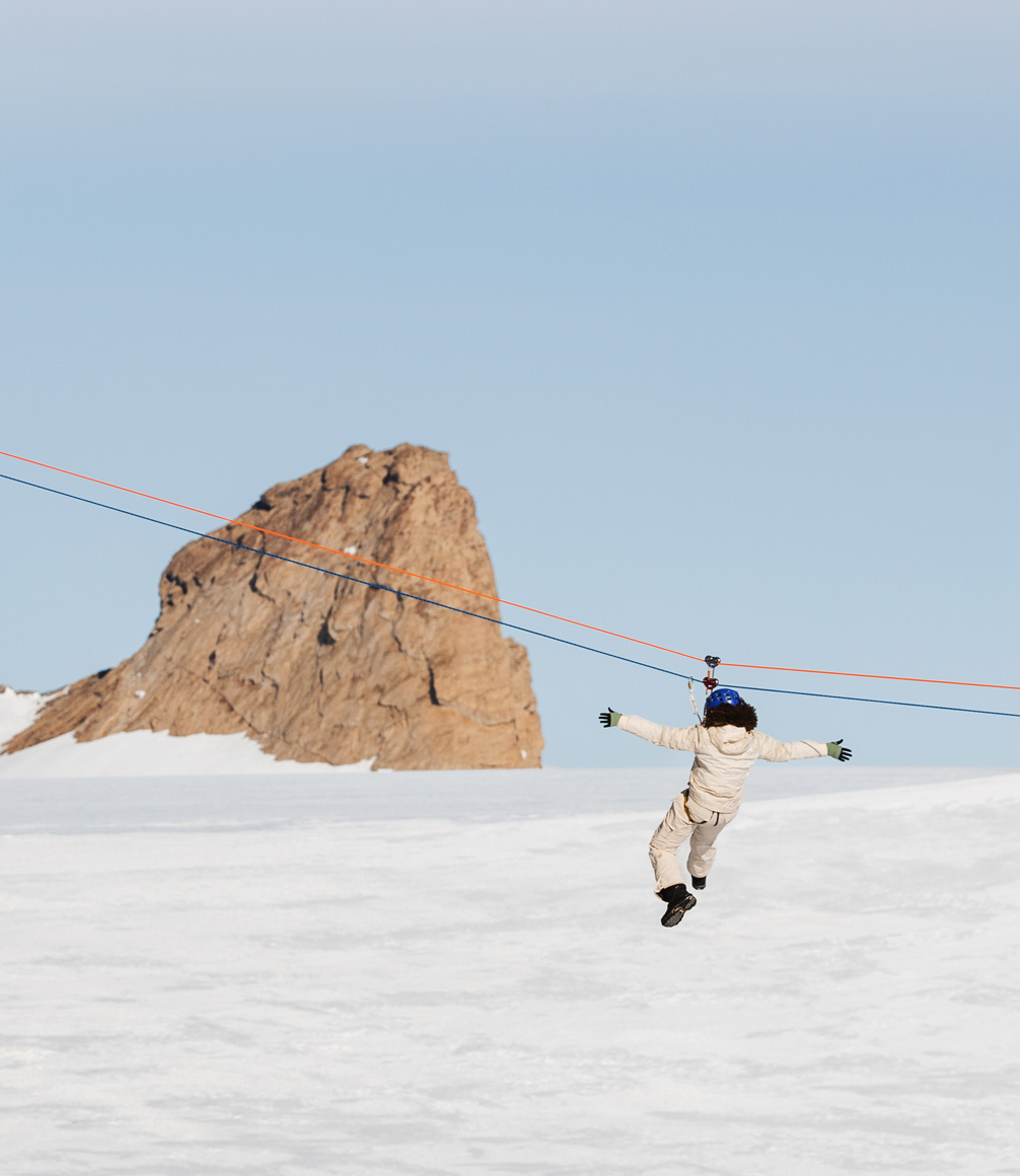 guest zip lining across the ice of antarctica from the white desert camp