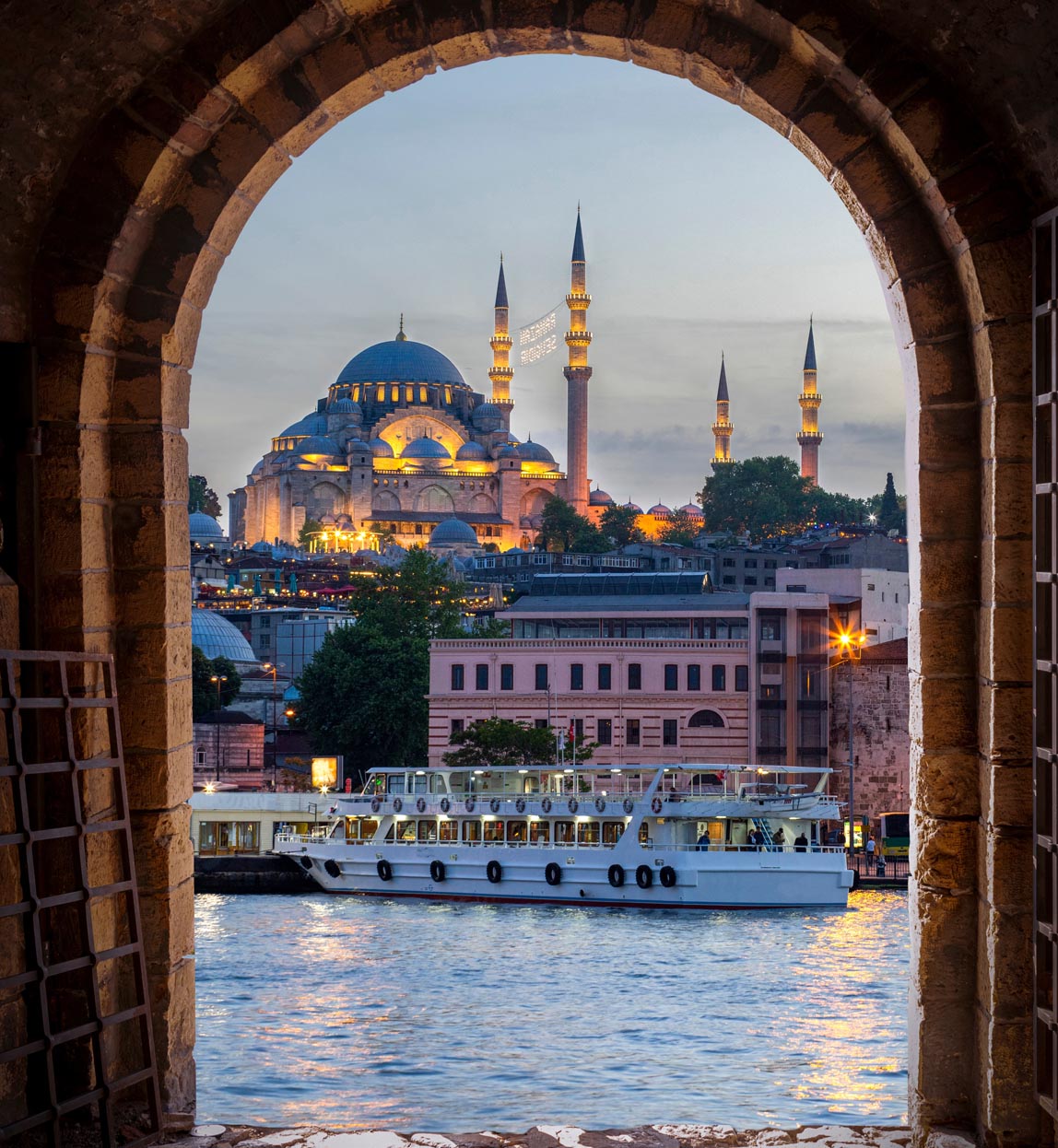 view of the old city including the hagia sofia through an archway across the river